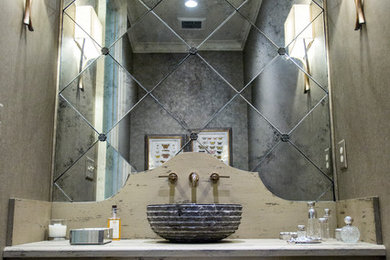 アトランタにあるラグジュアリーな広いトランジショナルスタイルのおしゃれなトイレ・洗面所 (ベッセル式洗面器、ヴィンテージ仕上げキャビネット、木製洗面台、ミラータイル、グレーの洗面カウンター) の写真