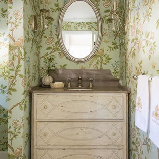Aménagement d'un WC et toilettes romantique avec un lavabo encastré, un placard en trompe-l'oeil, des portes de placard en bois clair, un mur vert, un sol en carrelage de céramique, un plan de toilette en marbre et un plan de toilette marron.