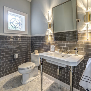 Inspiration for a transitional gray tile gray floor powder room remodel in Other with gray walls, a console sink and a one-piece toilet