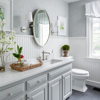 Inspiration for a mid-sized timeless gray floor powder room remodel in Boston with raised-panel cabinets, gray cabinets, gray walls, an undermount sink and white countertops
