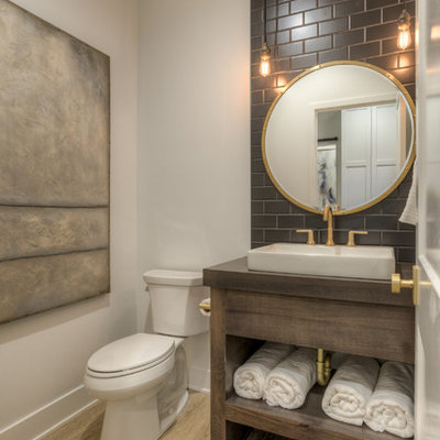 Inspiration for a country gray tile, brown tile and subway tile brown floor powder room remodel in Omaha with open cabinets, dark wood cabinets, a two-piece toilet, white walls, a console sink, wood countertops and gray countertops