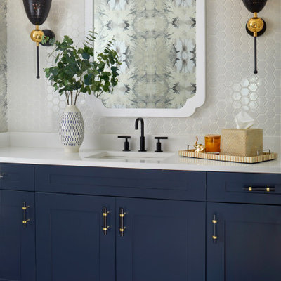 Mid-sized transitional white tile and ceramic tile slate floor and gray floor powder room photo in Denver with recessed-panel cabinets, blue cabinets, multicolored walls, a drop-in sink, solid surface countertops and white countertops