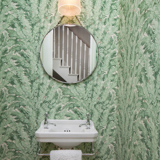 Photo of a medium sized traditional cloakroom in London with orange walls and a wall-mounted sink.