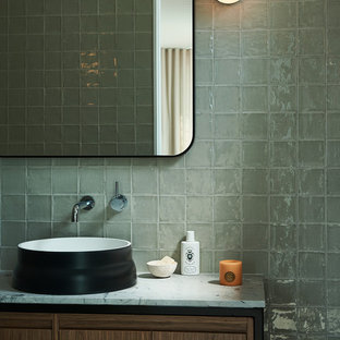 Design ideas for a contemporary powder room in Sydney with flat-panel cabinets, medium wood cabinets, gray tile, grey walls, a vessel sink, marble benchtops and white benchtops.