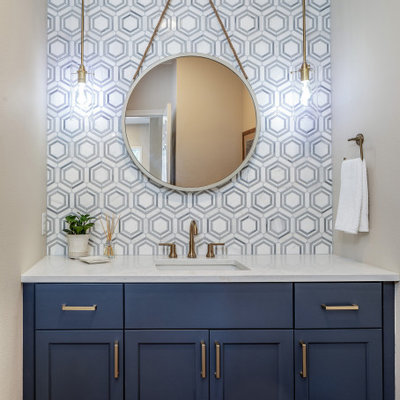 Powder room - small coastal white tile and marble tile medium tone wood floor and brown floor powder room idea in Seattle with shaker cabinets, blue cabinets, gray walls, an undermount sink, quartz countertops and white countertops