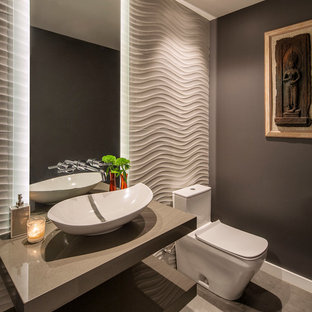 Ispirazione per un bagno di servizio design con nessun'anta, WC monopezzo, pareti grigie, pavimento in cemento, lavabo a bacinella, top in superficie solida, pavimento grigio e top grigio