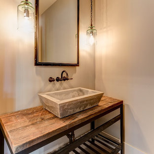 Réalisation d'un WC et toilettes urbain avec un placard en trompe-l'oeil, un mur beige, un sol en bois brun, une vasque, un plan de toilette en bois et un plan de toilette marron.