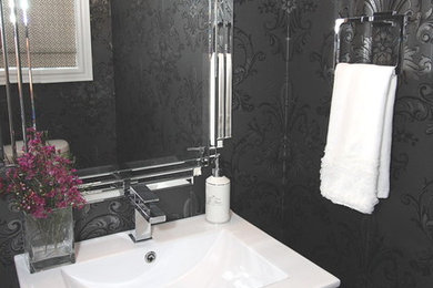 Immagine di un bagno di servizio boho chic con lavabo integrato, ante lisce, ante grigie, piastrelle bianche, piastrelle in pietra, pareti nere e pavimento in marmo