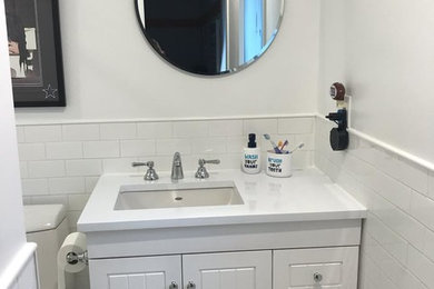 Powder room - small transitional white tile slate floor and white floor powder room idea in New York with white cabinets, white walls, an integrated sink, quartzite countertops and white countertops