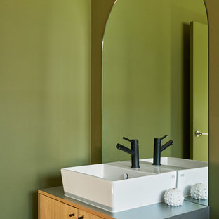 Photo of a contemporary powder room in Melbourne with flat-panel cabinets, light wood cabinets, green walls, a vessel sink and blue benchtops.