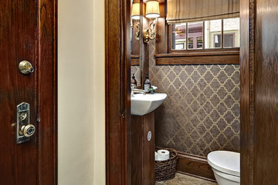 Powder room - small transitional gray tile marble floor powder room idea in Minneapolis with dark wood cabinets, a wall-mount toilet and brown walls