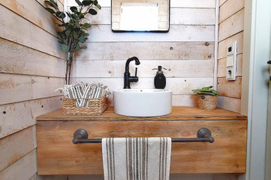 Mediterrane Gästetoilette mit hellbraunen Holzschränken und schwebendem Waschtisch