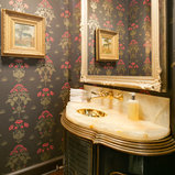 Example of a classic dark wood floor powder room design in DC Metro with an undermount sink, green cabinets, onyx countertops and multicolored walls