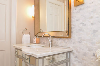 Ejemplo de aseo clásico renovado pequeño con armarios tipo mueble, baldosas y/o azulejos de mármol, suelo de madera clara, lavabo bajoencimera y encimera de mármol