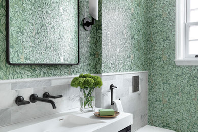 Inspiration for a transitional white tile and marble tile gray floor powder room remodel in St Louis with dark wood cabinets, a wall-mount toilet, green walls, an integrated sink and white countertops