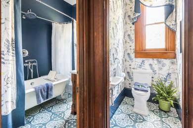 Imagen de aseo tradicional pequeño con sanitario de dos piezas, paredes multicolor, suelo de azulejos de cemento, lavabo suspendido y suelo multicolor