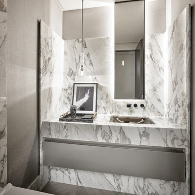 Example of a trendy white tile dark wood floor and brown floor powder room design in Miami with flat-panel cabinets, gray cabinets, gray walls, an undermount sink, white countertops and a floating vanity