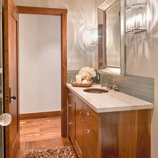 Immagine di un bagno di servizio chic con lavabo sottopiano, ante in stile shaker, ante in legno scuro, WC monopezzo, piastrelle di vetro e pareti grigie