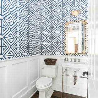 Cette photo montre un WC et toilettes bord de mer avec un WC séparé, un mur bleu, un sol en bois foncé, un plan vasque et un sol marron.