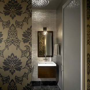 Industrial powder room in Chicago with a wall-mount sink, dark wood cabinets and gray tile.