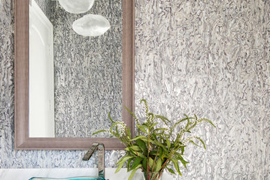 Inspiration for a mid-sized coastal porcelain tile and gray floor powder room remodel in Miami with furniture-like cabinets, medium tone wood cabinets, a one-piece toilet, blue walls, a vessel sink and marble countertops