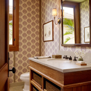 Idee per un bagno di servizio tropicale con lavabo sottopiano, nessun'anta, ante in legno scuro e piastrelle beige