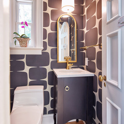 Powder room - small transitional medium tone wood floor and brown floor powder room idea in Kansas City with furniture-like cabinets, black cabinets, a one-piece toilet, black walls, an undermount sink, quartz countertops and white countertops
