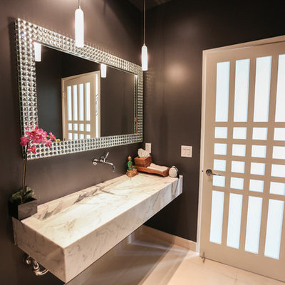 Example of a small minimalist marble floor powder room design in Los Angeles with black walls, marble countertops and a trough sink