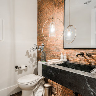 Foto di un piccolo bagno di servizio minimal con WC a due pezzi, piastrelle multicolore, piastrelle arancioni, piastrelle a listelli, pareti bianche, lavabo integrato, top nero, nessun'anta e ante nere