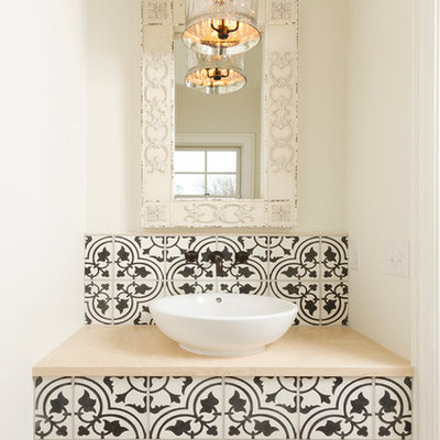 Inspiration for a small mediterranean cement tile, black and white tile and beige tile travertine floor powder room remodel in Minneapolis with a vessel sink, limestone countertops and white walls