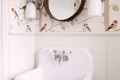 Ejemplo de aseo tradicional renovado con paredes multicolor, lavabo suspendido, panelado, boiserie y papel pintado