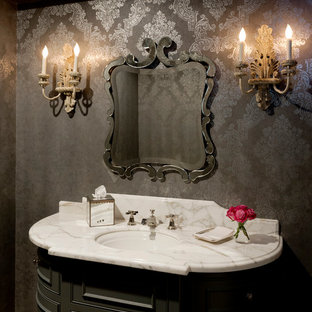 Réalisation d'un WC et toilettes victorien avec un placard en trompe-l'oeil, des portes de placard grises, un mur gris, un plan de toilette en marbre, un lavabo encastré et un plan de toilette blanc.