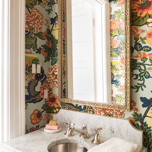 Example of an eclectic powder room design with multicolored walls, a console sink and marble countertops