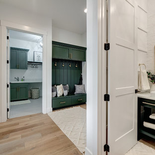 Esempio di un bagno di servizio country di medie dimensioni con consolle stile comò, ante verdi, WC a due pezzi, pareti bianche, parquet chiaro, lavabo a bacinella, top in superficie solida, pavimento marrone e top bianco