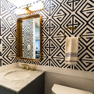 Exemple d'un petit WC et toilettes tendance avec un placard à porte plane, des portes de placard grises, un WC séparé, un mur bleu, un sol en marbre, un lavabo encastré, un plan de toilette en marbre, un sol gris et un plan de toilette gris.