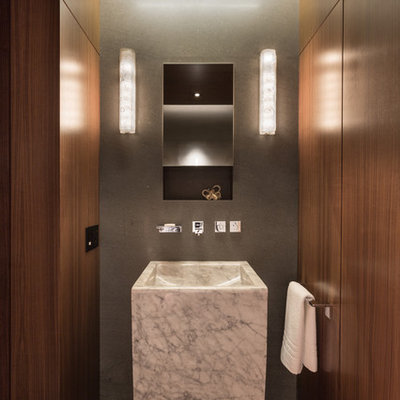 Example of a mid-sized minimalist gray tile powder room design in New York with a pedestal sink