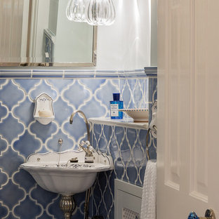 Réalisation d'un petit WC et toilettes victorien avec un carrelage bleu, des carreaux de céramique, un mur blanc et un lavabo suspendu.