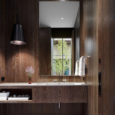 Example of a minimalist white tile limestone floor and gray floor powder room design in Denver with flat-panel cabinets, medium tone wood cabinets, an integrated sink, limestone countertops and brown walls