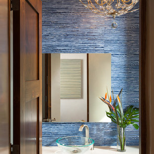 Aménagement d'un petit WC et toilettes sud-ouest américain avec une vasque, un mur bleu, un plan de toilette en surface solide et un carrelage bleu.