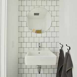 Idées déco pour un petit WC et toilettes industriel avec un mur blanc, un lavabo suspendu, un carrelage blanc, des carreaux de céramique et un sol noir.