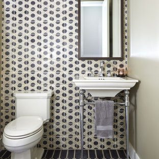 Inspiration pour un WC et toilettes traditionnel avec un carrelage noir et blanc, un mur gris, un plan vasque et un sol noir.
