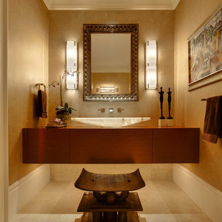 Idées déco pour un WC et toilettes exotique avec une vasque, un carrelage beige et un mur beige.