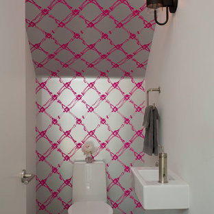 Idee per un piccolo bagno di servizio design con lavabo sospeso, WC monopezzo, pareti multicolore e pavimento in cemento