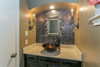 Example of a multicolored tile and mosaic tile porcelain tile powder room design in Houston with raised-panel cabinets, brown cabinets, yellow walls and a vessel sink