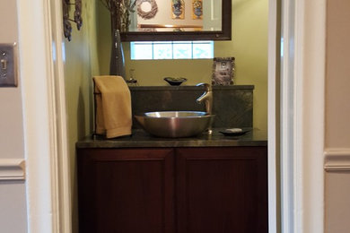Inspiration for a transitional medium tone wood floor powder room remodel in Chicago with shaker cabinets, brown cabinets, multicolored walls, a vessel sink, granite countertops and a two-piece toilet