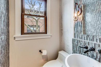 На фото: туалет в современном стиле с унитазом-моноблоком, разноцветной плиткой, плиткой мозаикой, серыми стенами и настольной раковиной с