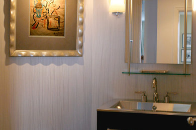 ジャクソンビルにある高級な小さなコンテンポラリースタイルのおしゃれなトイレ・洗面所 (フラットパネル扉のキャビネット、濃色木目調キャビネット、分離型トイレ、白い壁、濃色無垢フローリング、オーバーカウンターシンク、ステンレスの洗面台、茶色い床) の写真