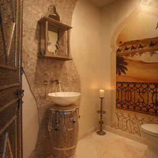 Idées déco pour un WC et toilettes méditerranéen de taille moyenne avec un mur beige, un sol en carrelage de céramique, une vasque, un carrelage beige et du carrelage en travertin.