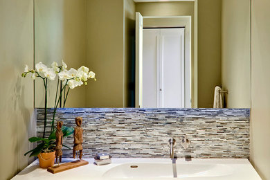 Modelo de aseo moderno de tamaño medio con baldosas y/o azulejos grises, paredes verdes, lavabo integrado y azulejos en listel