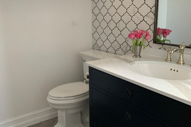 Small transitional ceramic tile ceramic tile and brown floor powder room photo in Miami with furniture-like cabinets, black cabinets, white walls, an undermount sink, quartzite countertops, white countertops and a freestanding vanity